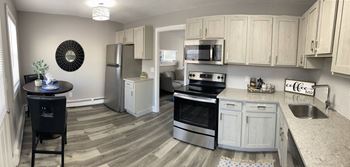 A kitchen with white cabinets and stainless steel appliances